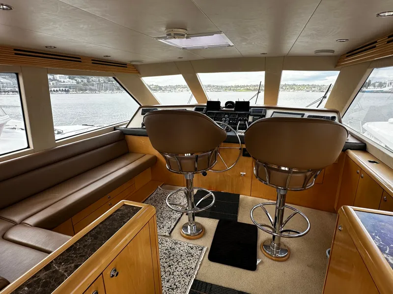 Slide: The Image of Interior of a 2000 Hatteras 70 Convertible with two swivel chairs and a sofa. - 35