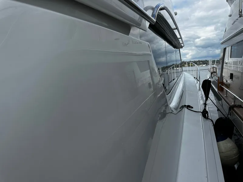 Slide: The Image of The 2000 Hatteras 70 Convertible is docked. Smooth white surface and modern design. - 43