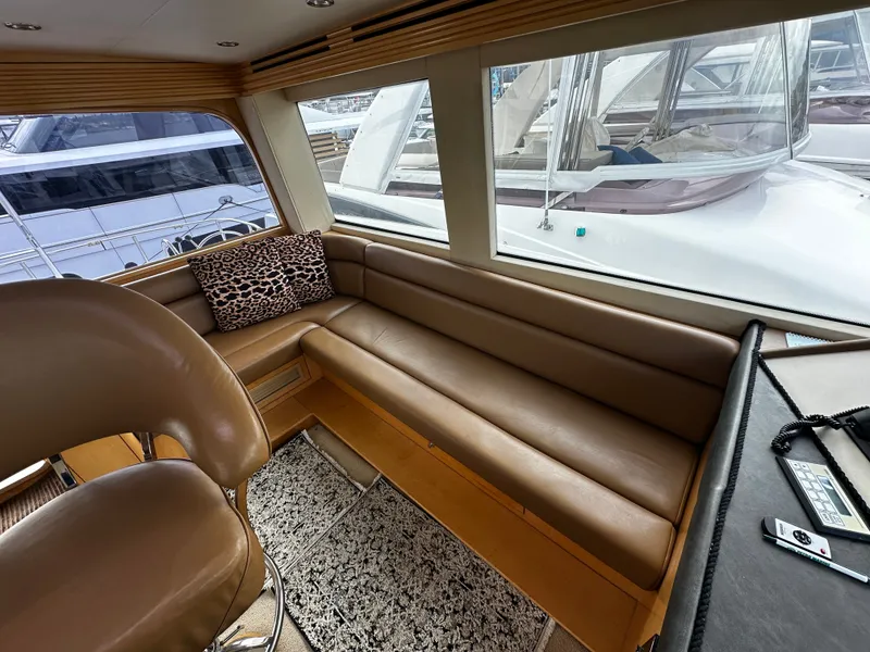 Slide: The Image of Interior of a 2000 Hatteras 70 Convertible with leather sofa and large windows. - 41