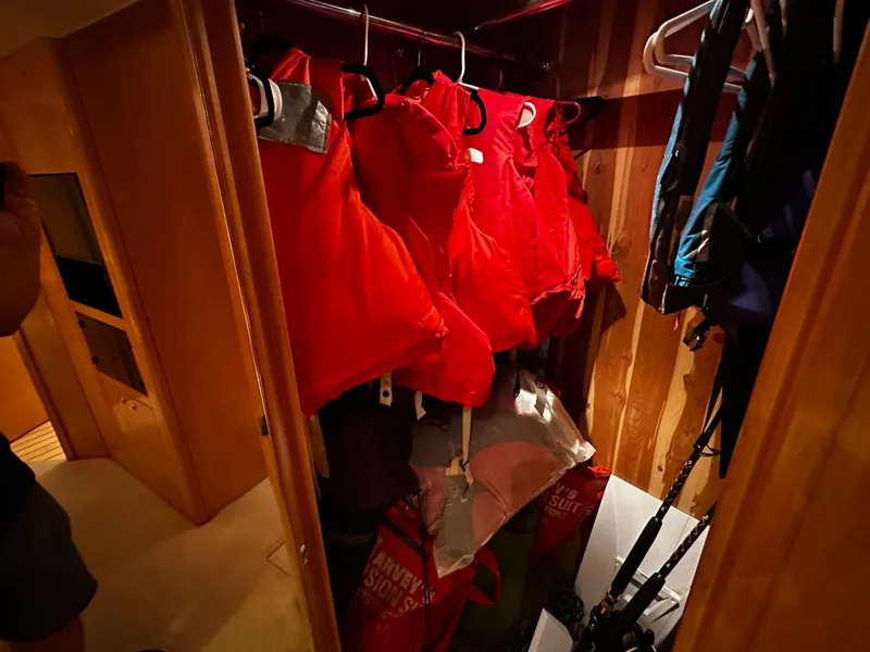 Slide: The Image of A closet on a 2000 Hatteras 70 Convertible with red life jackets. - 18