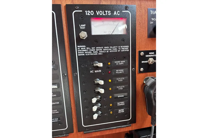 Slide: The Image of Electrical panel of a 2000 Island Packet 380 sailboat, showing 120 volts AC controls. - 14