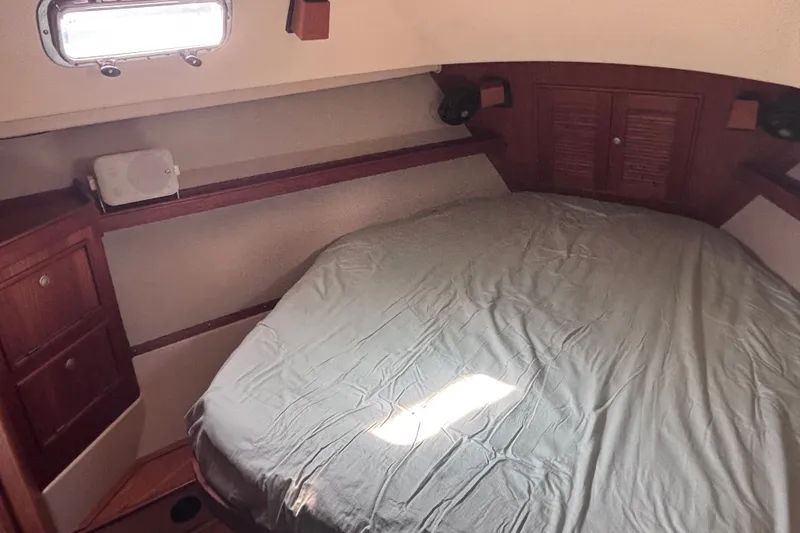 Slide: The Image of Cozy cabin interior of 2000 Island Packet 380 sailboat with bed and wooden storage. - 17