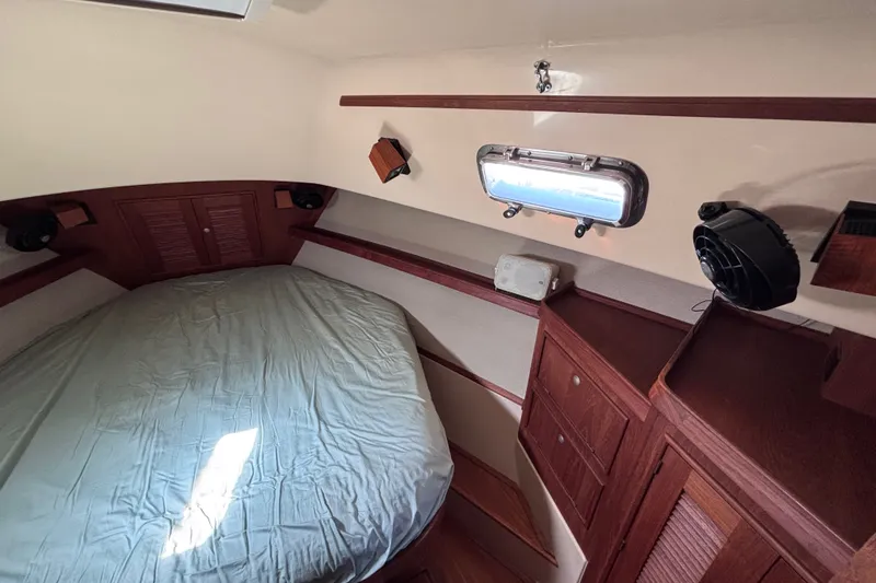 Slide: The Image of Cozy cabin interior of 2000 Island Packet 380 sailboat with bed and wooden cabinetry. - 23
