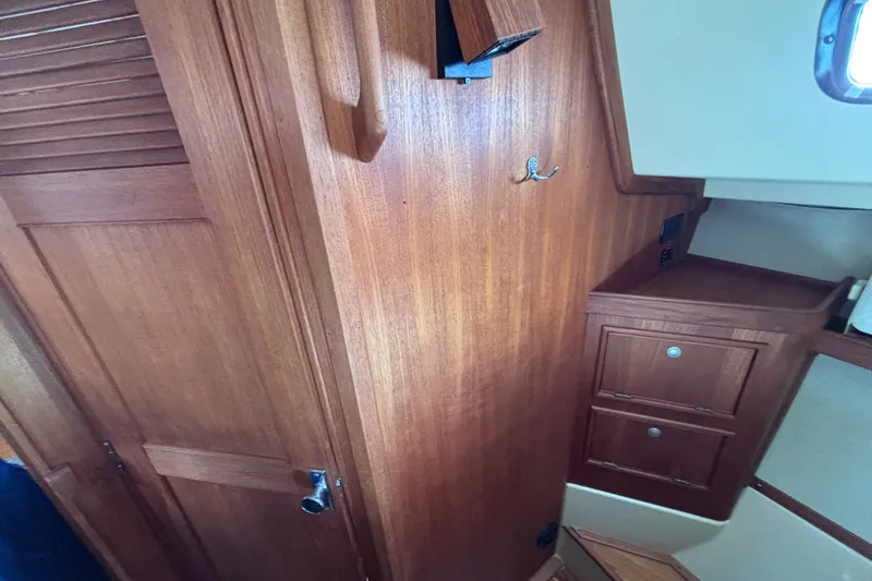 Slide: The Image of Interior of 2000 Island Packet 380 sailboat with wooden cabinetry and storage drawers. - 25