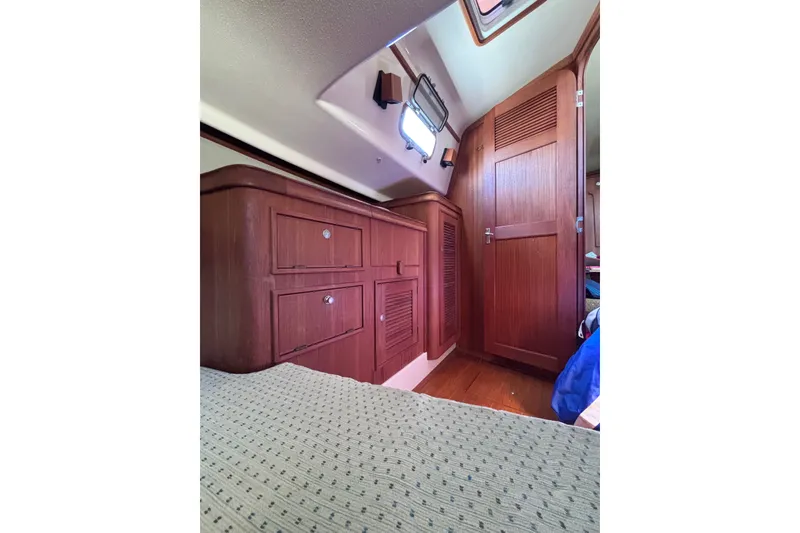 Slide: The Image of Interior of 2000 Island Packet 380 sailboat with wooden cabinetry and cozy sleeping area. - 37