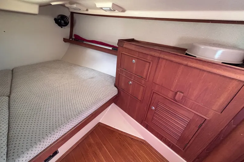 Slide: The Image of Cozy cabin interior of 2000 Island Packet 380 sailboat with wooden cabinetry and cushioned berth. - 36