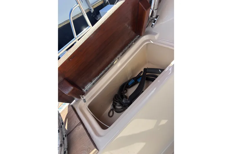 Slide: The Image of Open storage compartment on 2000 Island Packet 380 sailboat, containing coiled cables. - 57