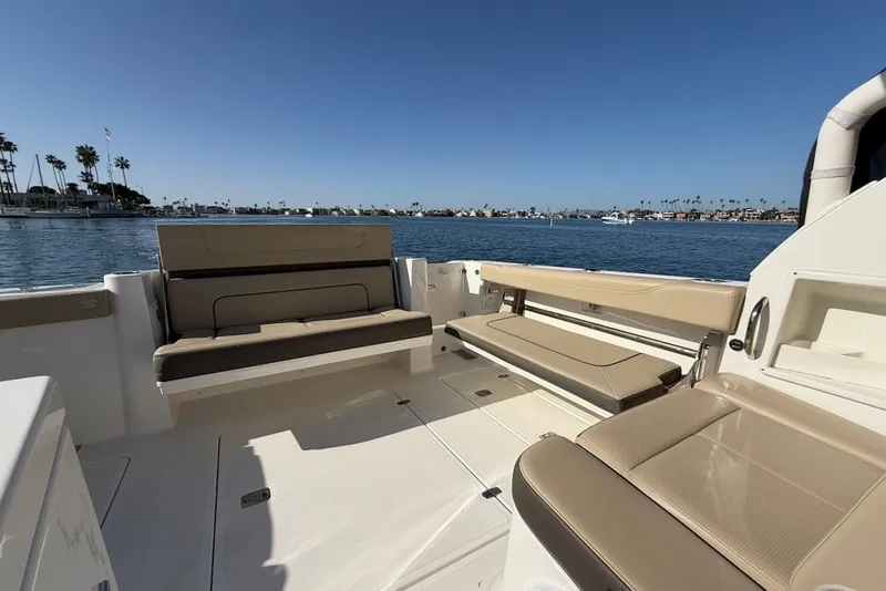 Slide: The Image of The image shows the cockpit of a 2021 Pursuit DC 326 Dual Console boat with beige seating. - 13