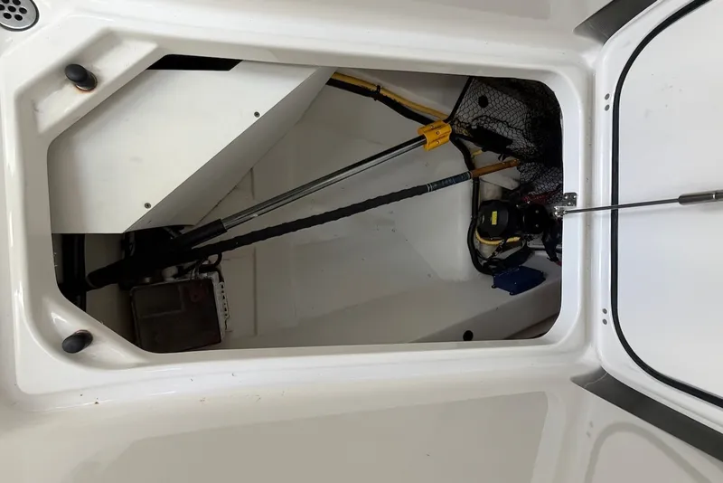 Slide: The Image of An open storage compartment on a boat with various equipment and a net. - 47