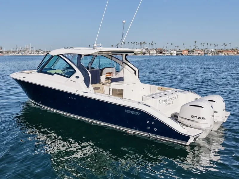 Slide: The Image of The 2021 Pursuit DC 326 Dual Console cruises on calm waters, featuring twin Yamaha engines. - 5