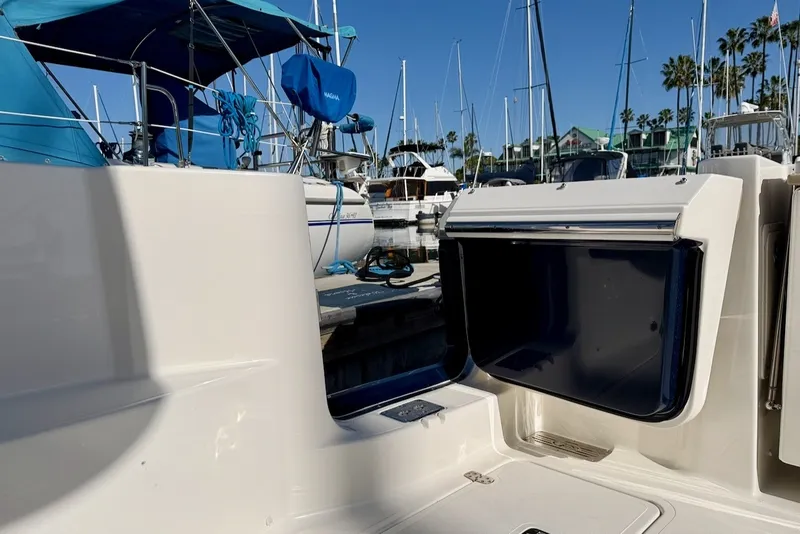 Slide: The Image of A 2021 Pursuit DC 326 Dual Console boat in a marina, surrounded by other boats and palm trees. - 22