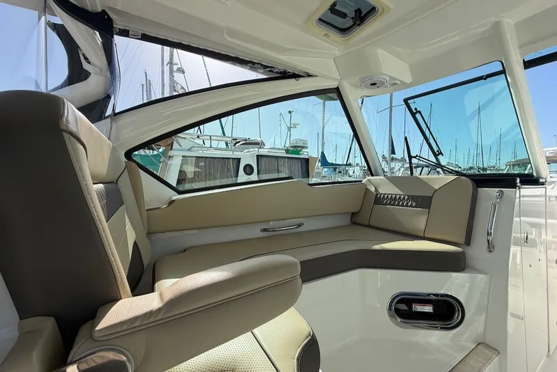 Slide: The Image of Interior of a 2021 Pursuit DC 326 Dual Console with beige upholstery and large windows. - 27