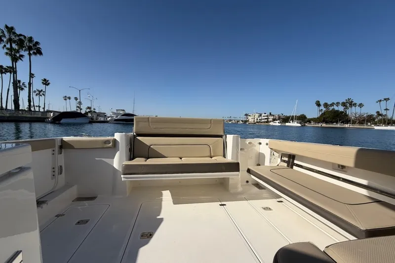 Slide: The Image of 2021 Pursuit DC 326 Dual Console with spacious cockpit and comfortable seating, on calm waters. - 14