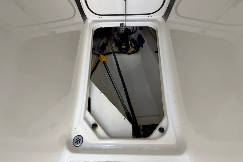 Slide: The Image of An open storage compartment on a boat with a white interior and visible cables. - 48