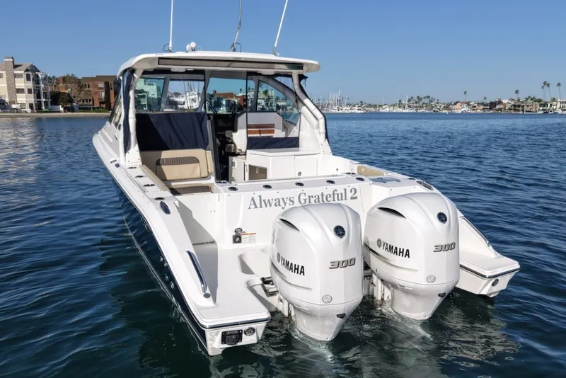 Slide: The Image of 2021 Pursuit DC 326 Dual Console with twin Yamaha engines on calm water. - 4