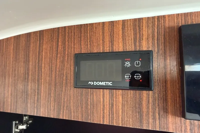 Slide: The Image of A Dometic control panel is embedded in a wood panel. - 49