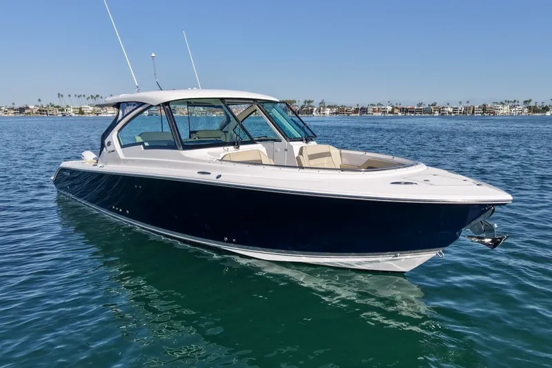 Slide: The Image of 2021 Pursuit DC 326 Dual Console on calm water with clear blue sky. - 7