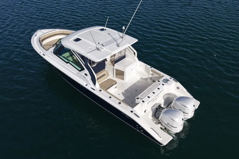 Slide: The Image of 2021 Pursuit DC 326 Dual Console on the water with twin outboard engines. - 1