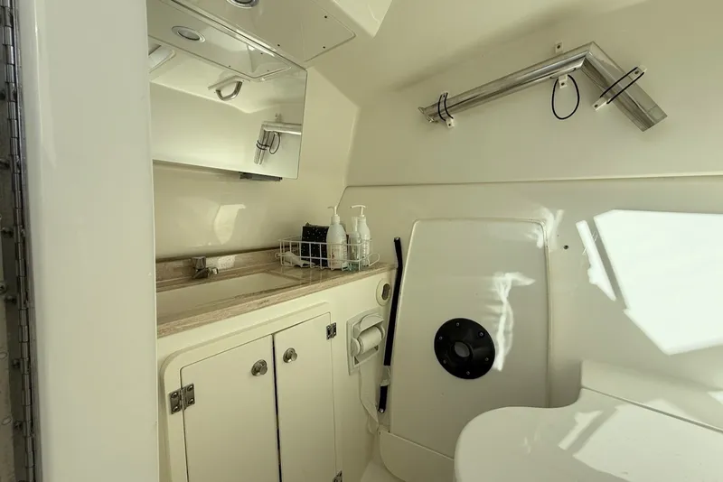 Slide: The Image of The image shows a clean, modern boat bathroom with a sink, mirror, and storage space. - 43