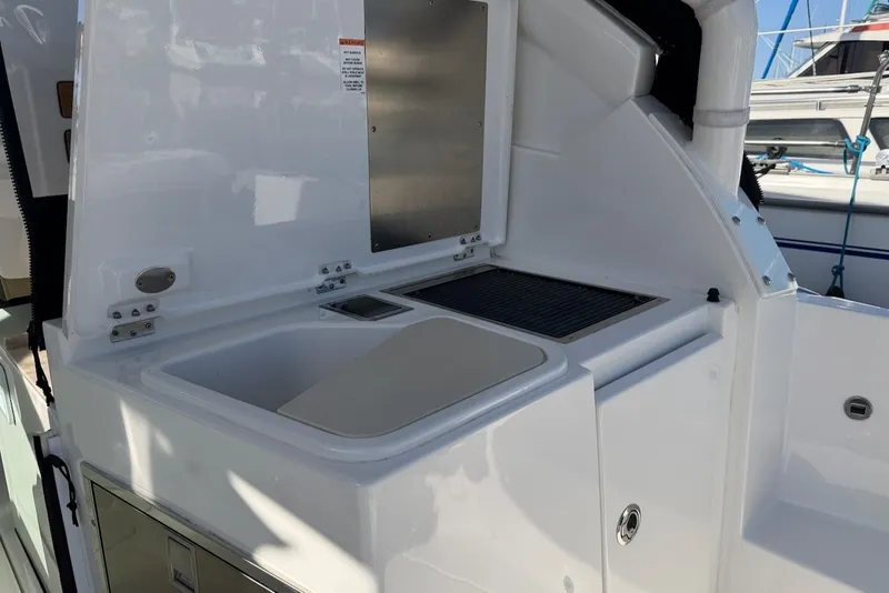 Slide: The Image of The 2021 Pursuit DC 326 Dual Console features a white exterior kitchen with a sink and grill. - 18