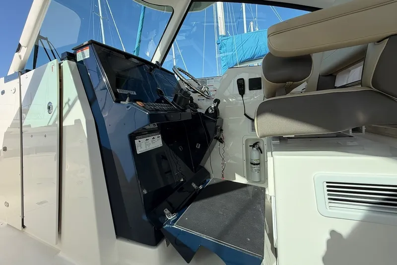 Slide: The Image of The image shows the cockpit of a 2021 Pursuit DC 326 Dual Console boat with modern controls and comfortable seating. - 31