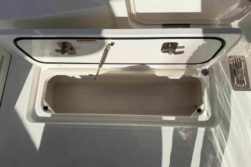 Slide: The Image of Open storage compartment on a 2021 Pursuit DC 326 Dual Console boat. - 24