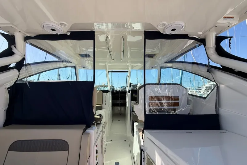 Slide: The Image of Interior view of a 2021 Pursuit DC 326 Dual Console with clear and blue covers. - 25