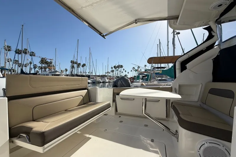 Slide: The Image of 2021 Pursuit DC 326 Dual Console with spacious cockpit and comfortable seating in a marina. - 11