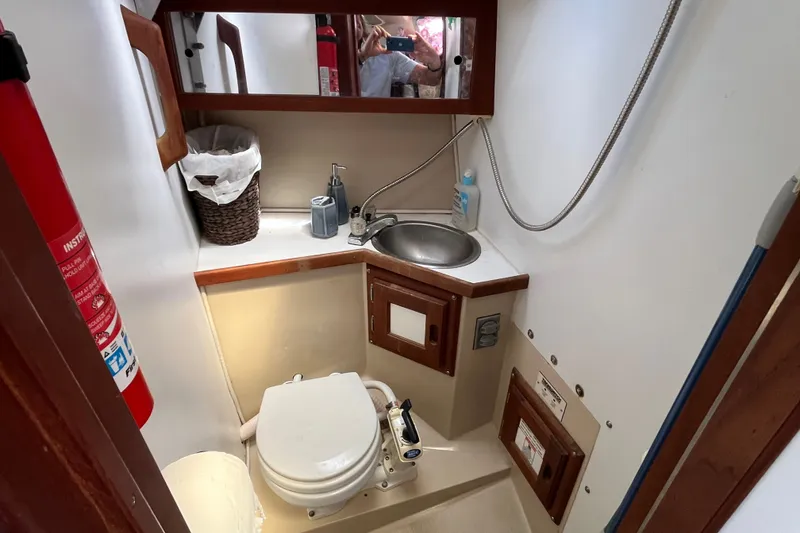 Slide: The Image of Compact bathroom in a 1985 Catalina 30 sailboat with sink, toilet, and storage. - 30