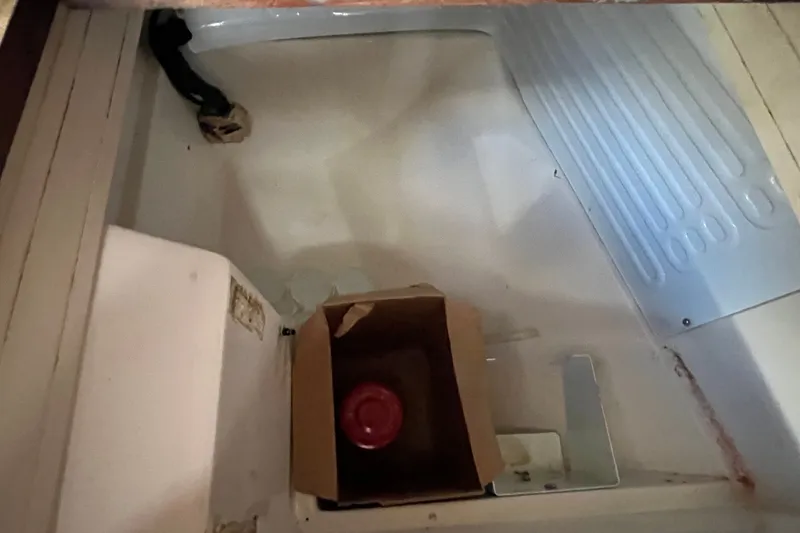 Slide: The Image of Interior of 1985 Catalina 30 sailboat with storage compartment and cardboard box. - 21