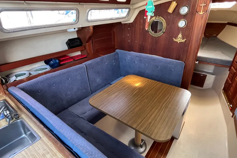 Slide: The Image of Interior of 1985 Catalina 30 sailboat with cozy dining area and wooden accents. - 16
