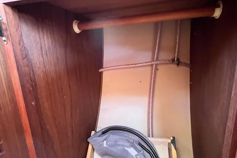 Slide: The Image of Interior of a 1985 Catalina 30 sailboat showing a wooden closet with a hanging rod. - 28