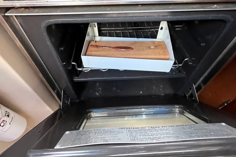 Slide: The Image of Open oven with a wooden-handled tool inside, aboard a 1985 Catalina 30 sailboat. - 24