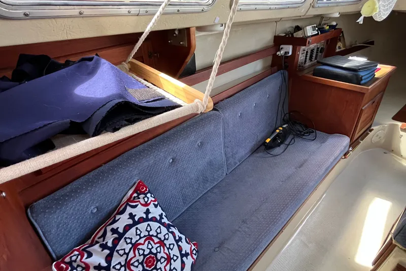 Slide: The Image of Interior of a 1985 Catalina 30 sailboat with blue cushions and nautical decor. - 17