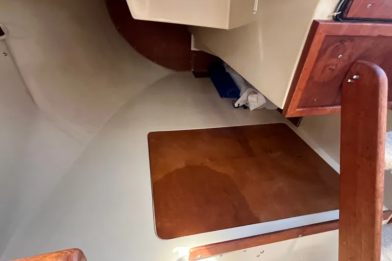 Slide: The Image of Interior of a 1985 Catalina 30 sailboat, featuring wooden cabinetry and flooring. - 18