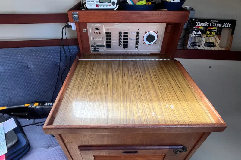 Slide: The Image of Electrical panel and teak care kit inside a 1985 Catalina 30 sailboat cabin. - 31