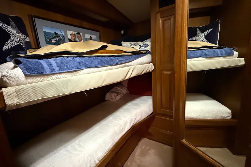 Slide: The Image of Cozy bunk beds in a 1989 Viking 48 Convertible yacht cabin with nautical decor. - 26