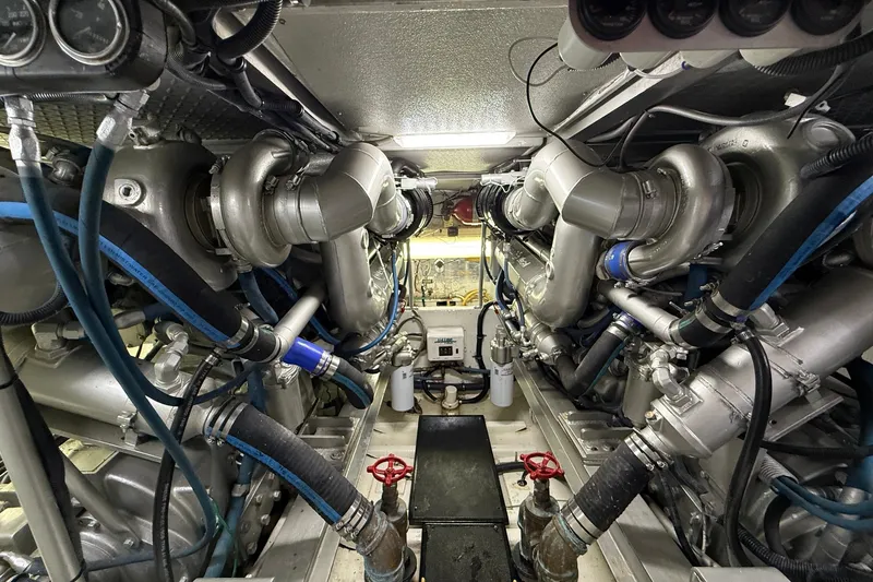 Slide: The Image of Engine room of a 1989 Viking 48 Convertible yacht, showcasing complex machinery and piping. - 35