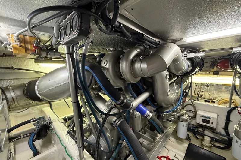 Slide: The Image of Engine room of a 1989 Viking 48 Convertible yacht, showcasing complex machinery and piping. - 38