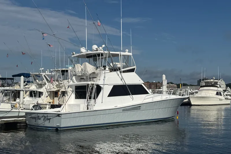 The Image of 1989 Viking 48 Convertible yacht docked in a marina under a clear blue sky. - 0