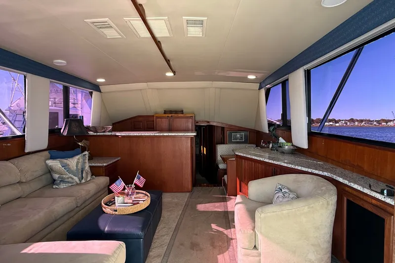 Slide: The Image of Interior of a 1989 Viking 48 Convertible yacht with cozy seating and panoramic windows. - 14