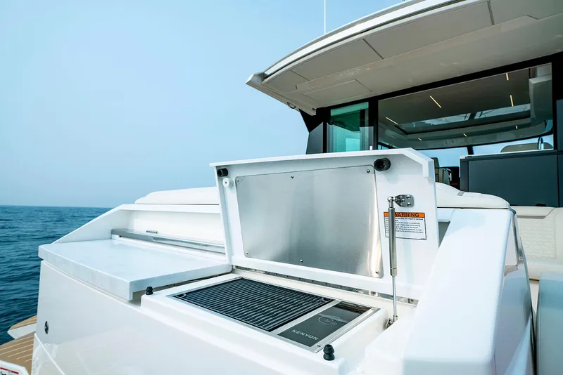 Slide: The Image of Manufacturer Provided Image: 2025 Tiara Yachts 48 LE yacht with open grill on deck, ocean backdrop. - 12