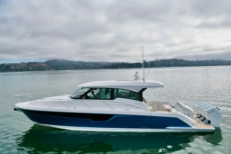 Slide: The Image of 2027 Tiara Yachts 48 LE cruising on calm waters under cloudy skies. - 13