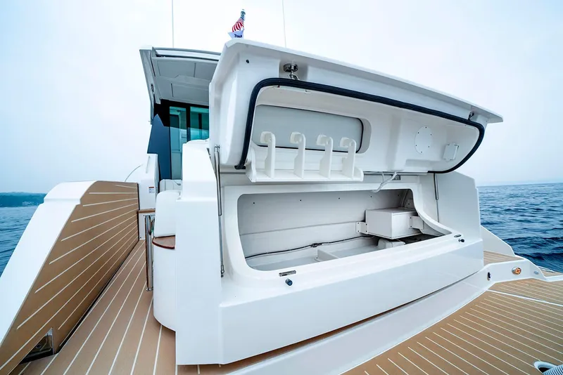 Slide: The Image of Manufacturer Provided Image: 2025 Tiara Yachts 48 LE with open storage compartment, docked on calm waters. - 9