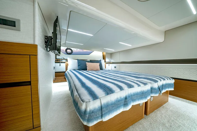 Slide: The Image of Manufacturer Provided Image: Luxurious cabin interior of 2025 Tiara Yachts 48 LE with striped bedding. - 18