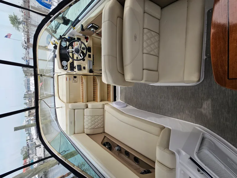 Slide: The Image of Interior of a 2019 Regal 28 Express with beige leather seating and a sleek helm station. - 8