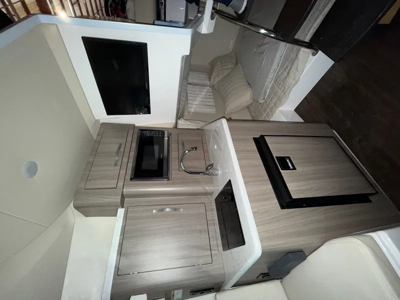 Slide: The Image of Interior of the 2019 Regal 28 Express with kitchenette, sink, microwave, and refrigerator. - 4