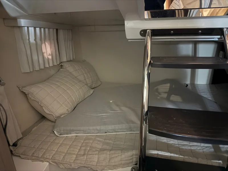 Slide: The Image of The 2019 Regal 28 Express cabin features a cozy bed with quilted pillows. - 14