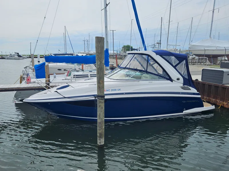 Slide: The Image of A 2019 Regal 28 Express boat docked in a marina, surrounded by other boats. - 6