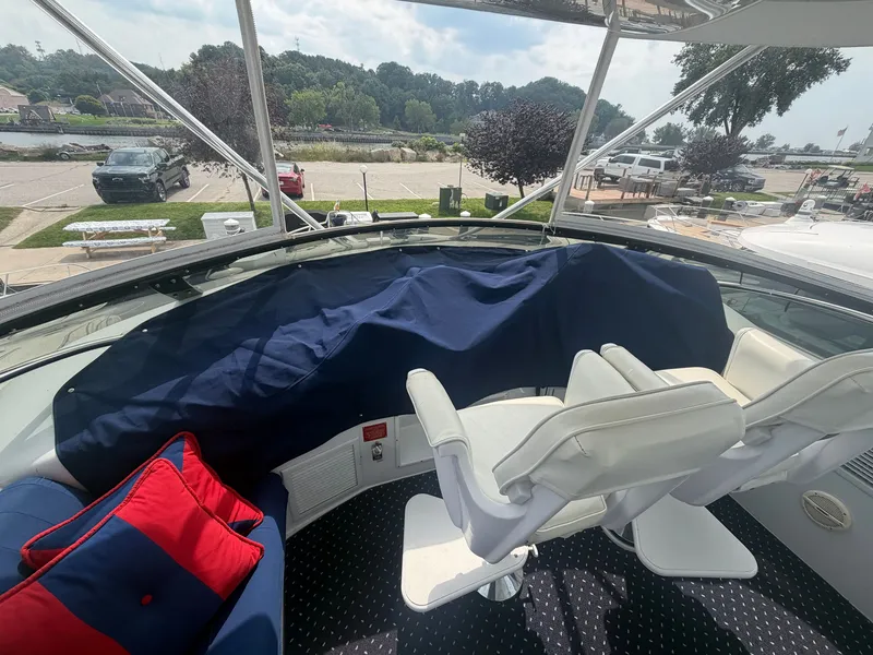 Slide: The Image of The image shows the cockpit of a 1999 Hatteras 52 Cockpit Motor Yacht with white seats and blue covers. - 31